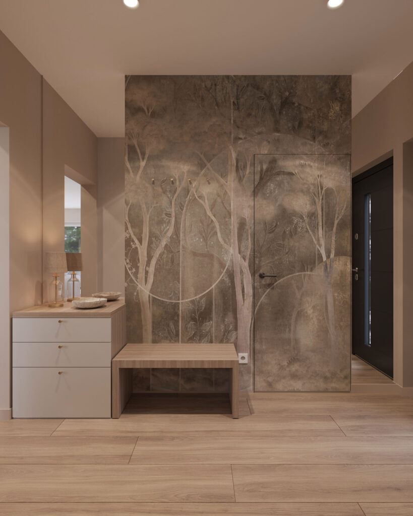 wiatrołap 4a Na zdjęciu jest wiatrołap, holl. Stoją tu: komoda, ławeczka. Nad komodą jest lustro bez ramy. Na ścianie jest przepiękna beżowa tapeta z plamami przypominającymi drzewa. Całość pomieszczenia utrzymana jest w jednolitej kolorystyce: beże i brązy. Na podłodze są panele. Obok drzwi wejściowych wisi ogromne lustro.